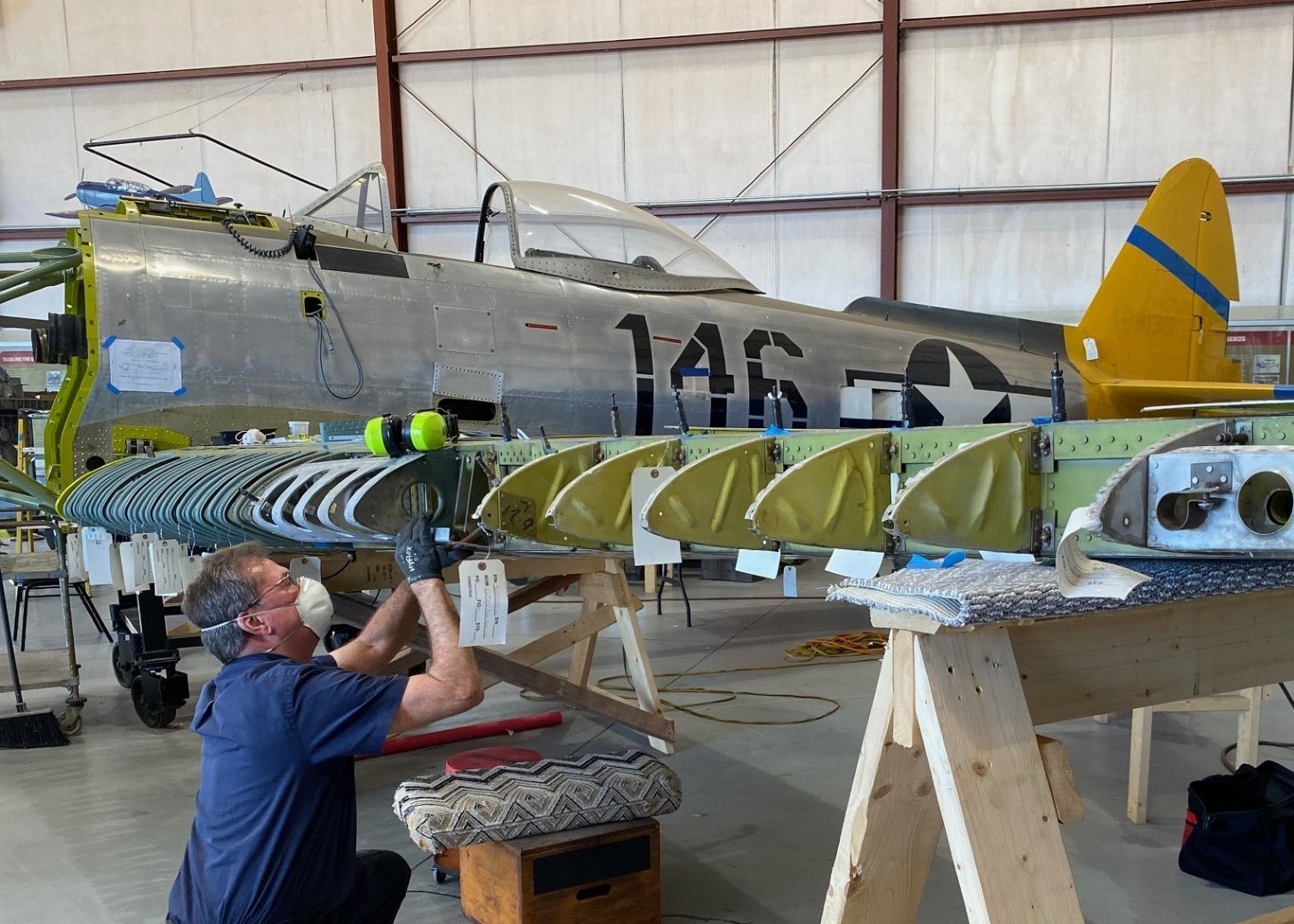 Photo of man working on the wing of vintage airplan