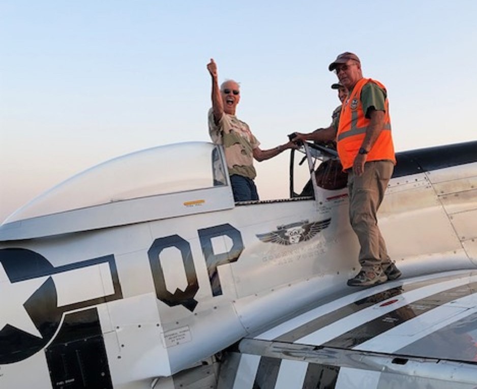 Image of man giving thumbs up while climbing out of P-15 World War II fighter